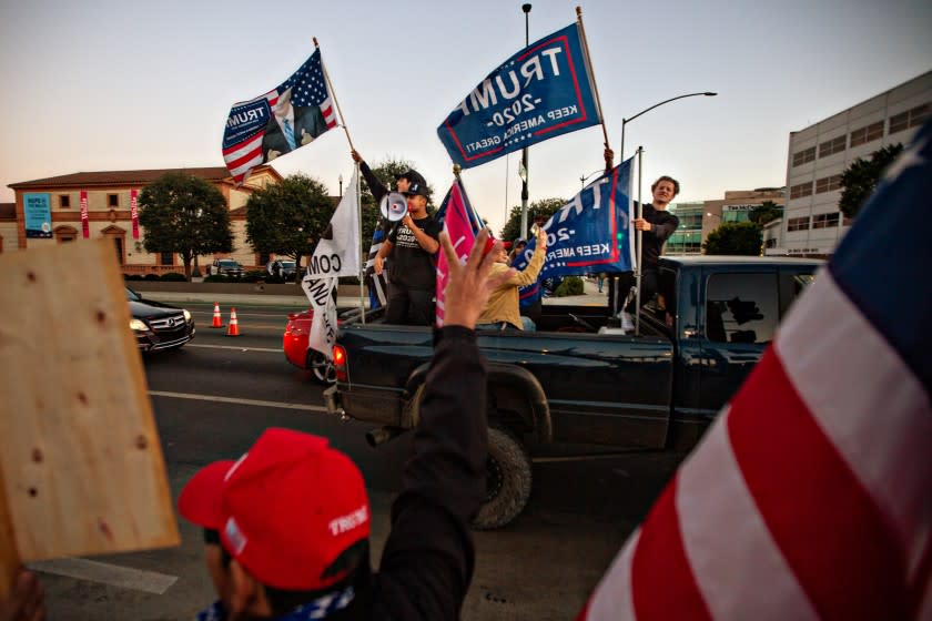 BEVERLY HILLS, CA - NOVEMBER 07: Trump supporters ride in the back of a truck at a rally in Beverly Hills as Joe Biden is elected president on Saturday, Nov. 7, 2020 in Beverly Hills, CA. (Jason Armond / Los Angeles Times)