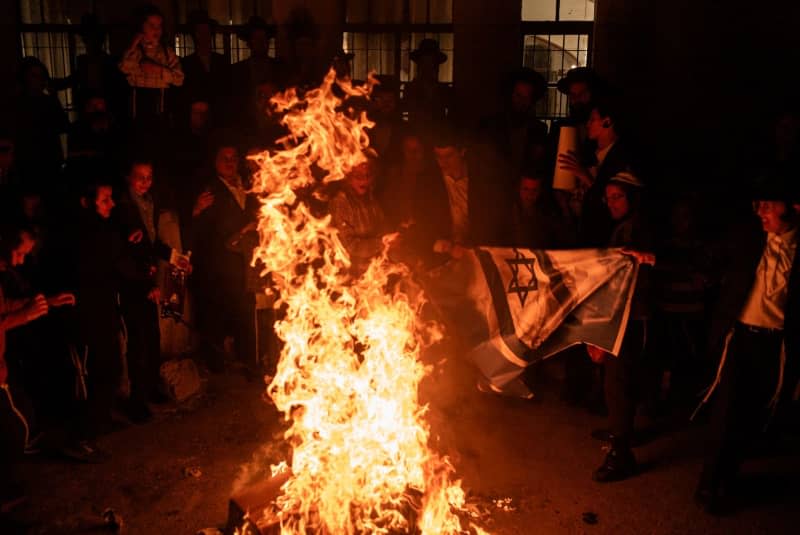 Ultra-Orthodox Jewish protesters burn Israeli flags during a rally against the creation of the state of Israel in Mea Shearim neighbourhood, as the country marks the 76th anniversary of its creation. Ilia Yefimovich/dpa