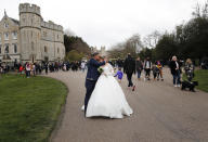 A newlywed couple kiss outside the gates of Windsor Castle, a day after the death of Britain's Prince Philip, in Windsor, England, Saturday, April 10, 2021. Britain's Prince Philip, the irascible and tough-minded husband of Queen Elizabeth II who spent more than seven decades supporting his wife in a role that mostly defined his life, died on Friday. (AP Photo/Frank Augstein)