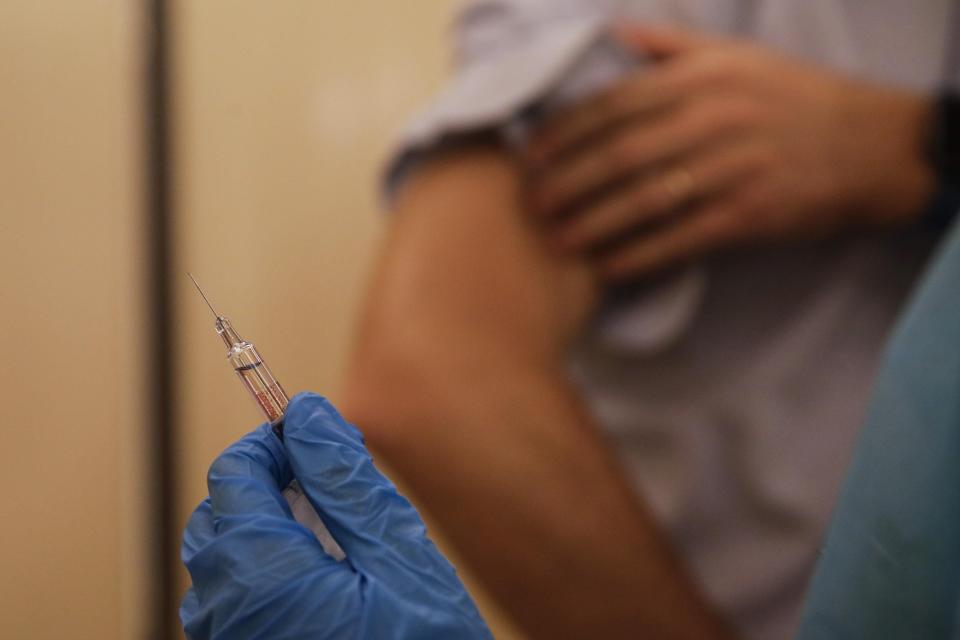 A nurse prepares to inject flu vaccine Jacopo Leoni at the Museum of science and technology in Milan, Italy, Wednesday, Nov. 4, 2020.