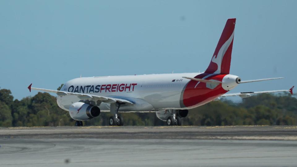 A Qantas red-tailed freighter, viewed from the ground from the rear.