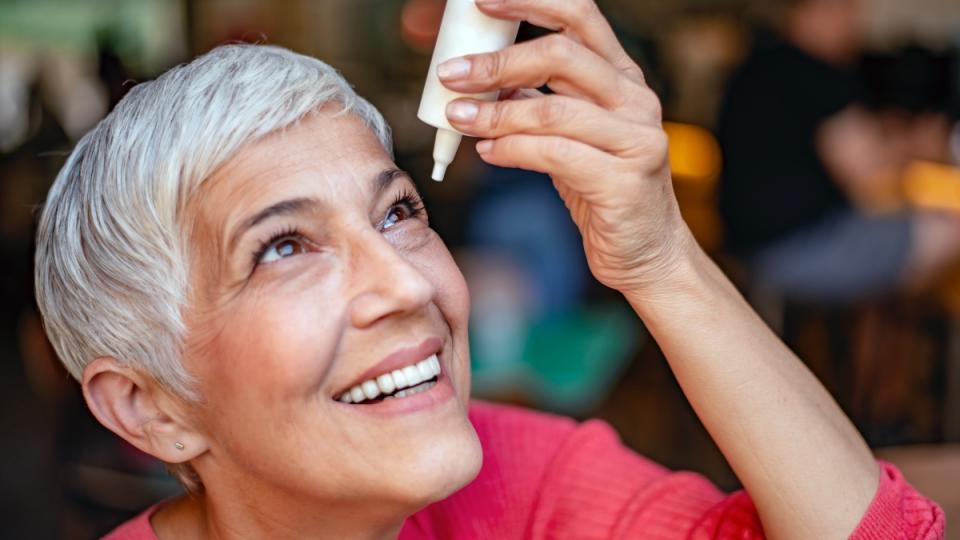 A woman with short grey hair using artificial tears to improve her vision in 7 days