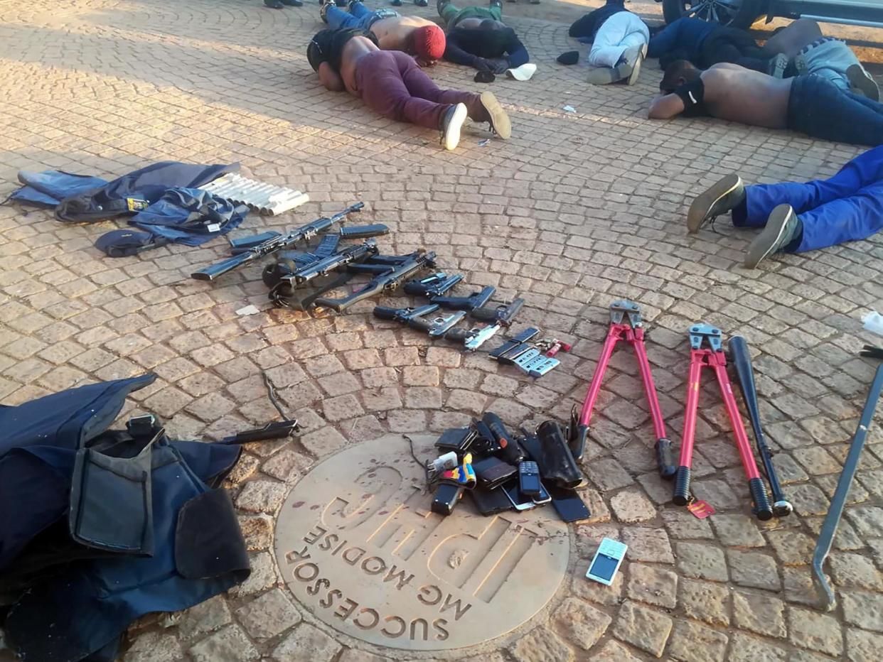 Arrested suspects and confiscated weapons are pictured at a church near Johannesburg after a siege on 11 July, 2020: South African Police Services via AP