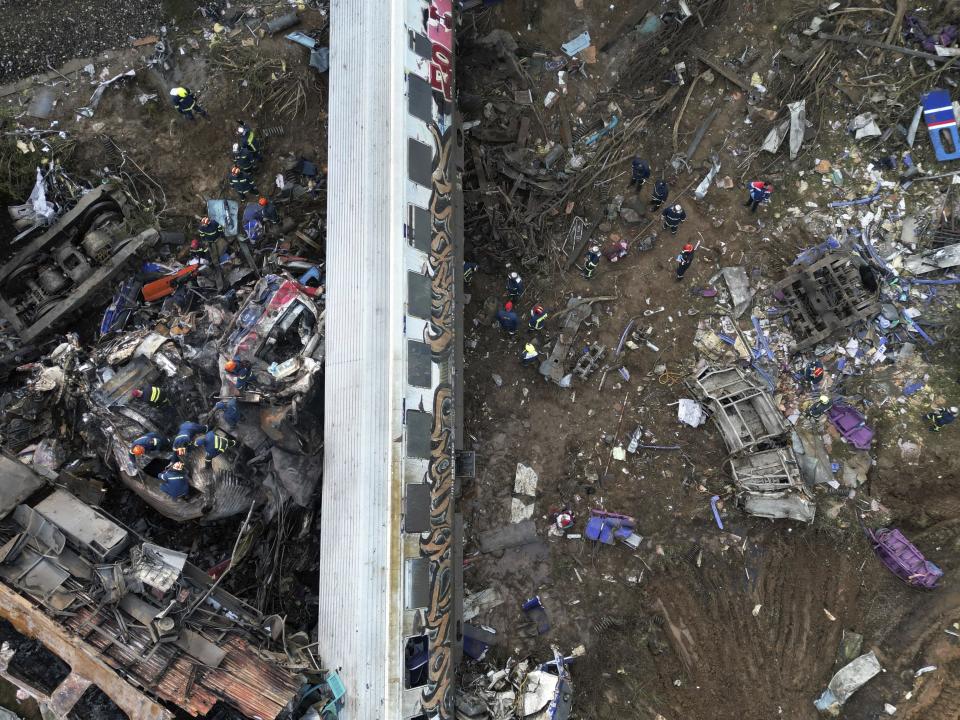 Firefighters and rescuers operate after a collision in Tempe near Larissa city, Greece, Wednesday, March 1, 2023. A train carrying hundreds of passengers has collided with an oncoming freight train in northern Greece, killing and injuring dozens passengers. (AP Photo/Vaggelis Kousioras)