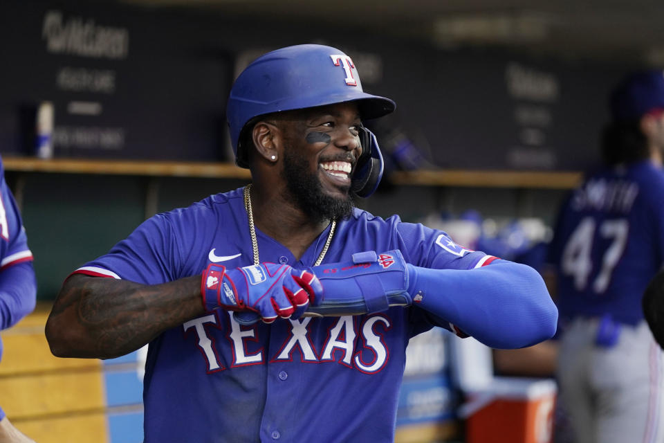 Texas Rangers' Adolis Garcia smiles in the dugout after scoring with Josh Jung on Jung's two-run home run during the seventh inning of a baseball game against the Detroit Tigers, Tuesday, May 30, 2023, in Detroit. (AP Photo/Carlos Osorio)