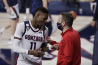 Gonzaga head athletic trainer Josh Therrien, right, speaks with guard Joel Ayayi before the team's NCAA college basketball game against Pepperdine in Spokane, Wash., Thursday, Jan. 14, 2021. The pandemic forced trainers to alter the way they do nearly everything. Training rooms were reconfigured with tables spread out for social distancing and limits were put on how many people are allowed in at a time. Masks became mandatory. Cleaning equipment and constant hand washing became a priority. Many schools have gone to appointment-based rehab schedules. (AP Photo/Young Kwak)