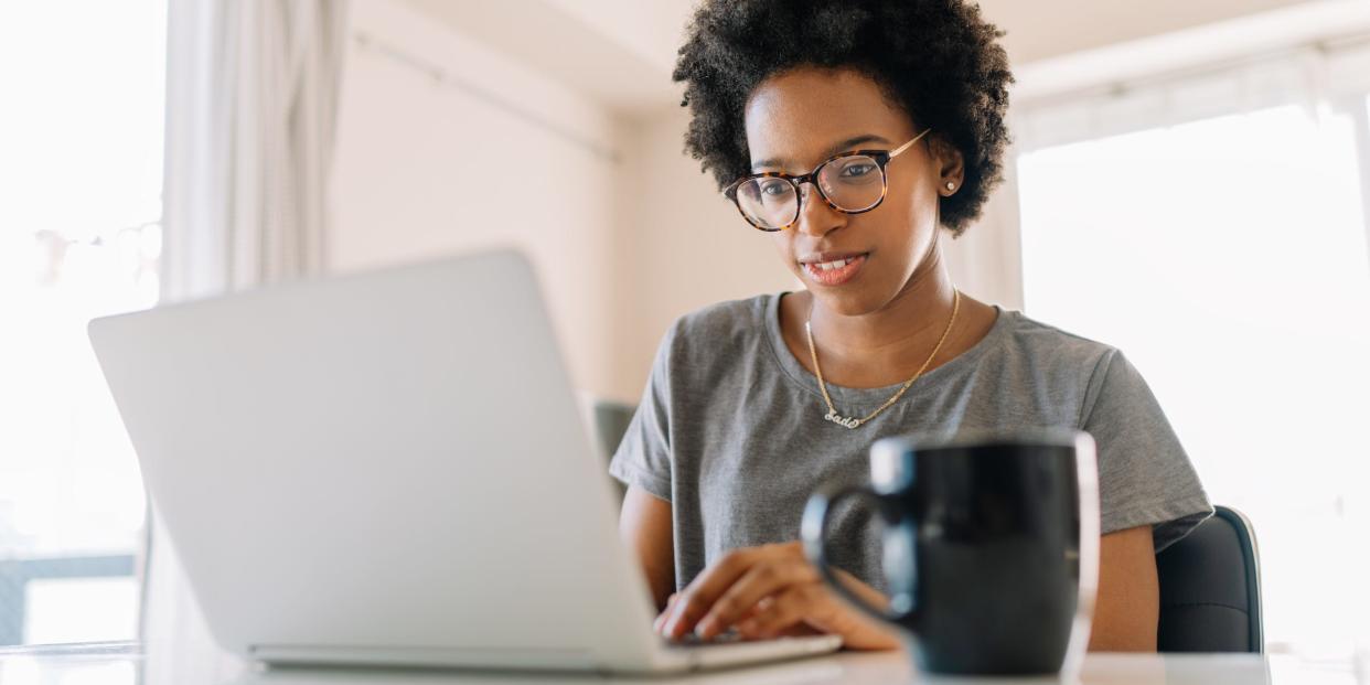 woman looking at laptop computer typing at home