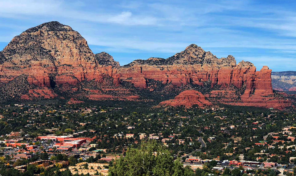 This 2018 photo shows the town of Sedona, Ariz., seen from the Airport Mesa Loop Trail. From left to right are Thunder Mountain, Sugar Loaf and Coffee Pot Rock. The sleepy Arizona town of Sedona has long been a refuge for hikers, romantics and soul searchers. There’s picturesque beauty in its earth-toned buildings and also in the glowing red rocks that surround town. And many visitors come looking for something besides this beauty: the so-called vortex where some say the earth’s energy crackles and creates sensations of healing and spiritual awakening. (AP Photo/Joseph Gedeon)