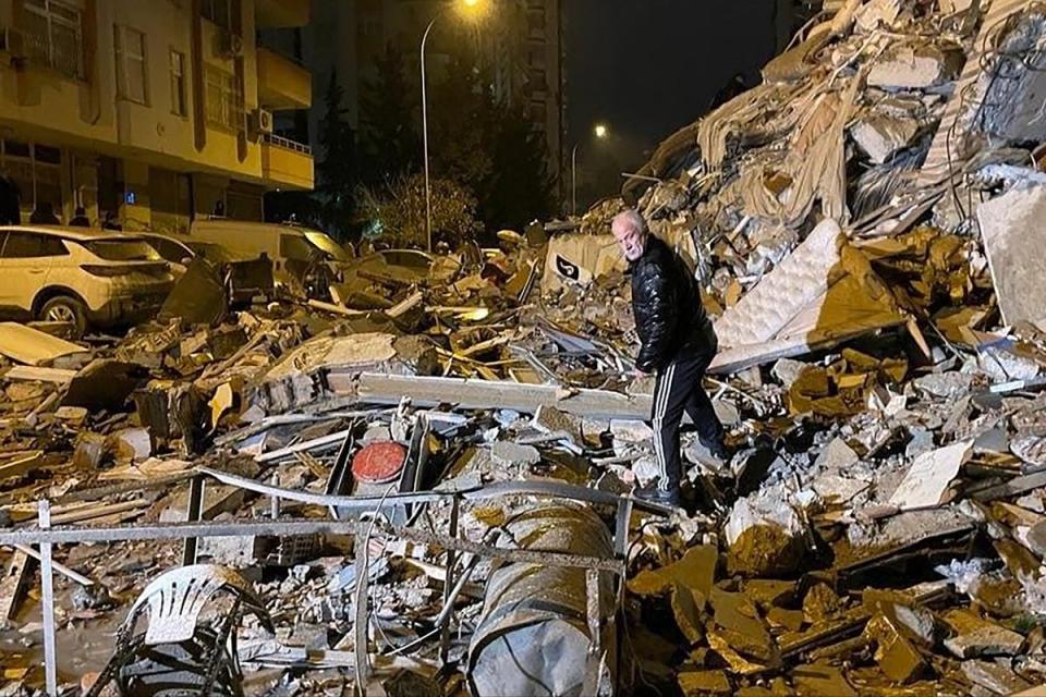 A man searches collapsed buildings in Diyarbakir, southern Turkey (AP)