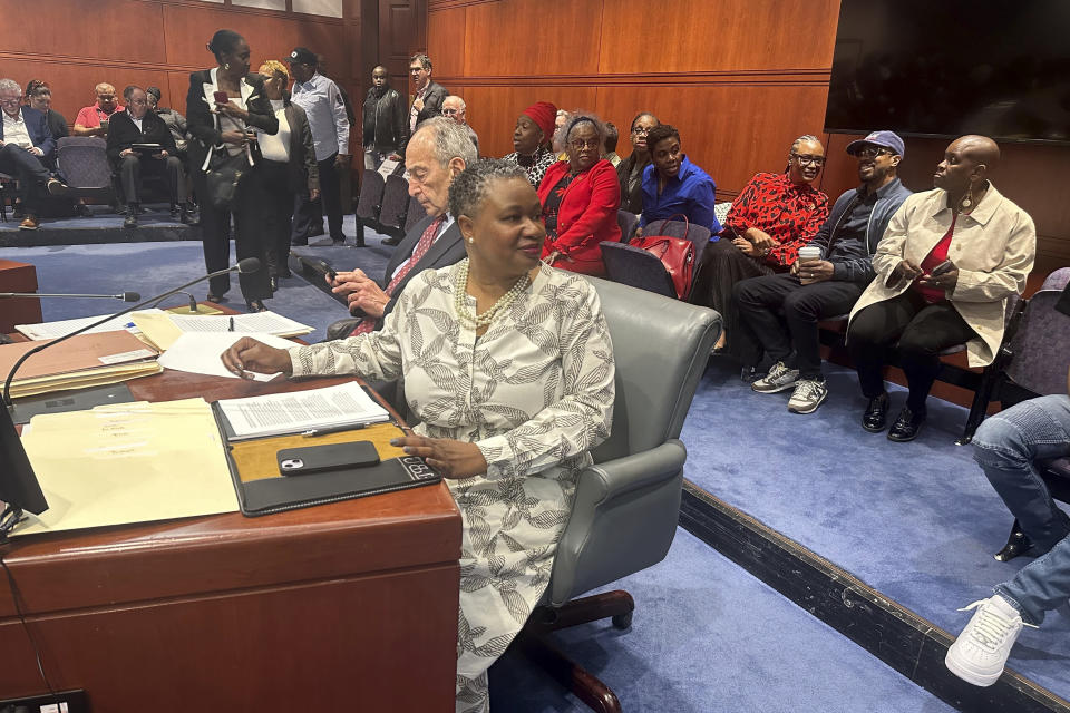 Connecticut Chief Public Defender Tashun Bowden-Lewis looks over at a group of supporters before a hearing at the Legislative Office Building in Hartford, Conn. on August 16, 2024, on whether she should keep her job mid allegations of misconduct. Many in the audience were Black women who wore red in support of Bowden-Lewis. (AP Photo/Susan Haigh)