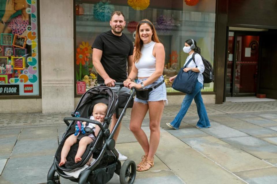 Elisabeth and Craig Walmsley and baby Darcia pictured outside Hamleys.