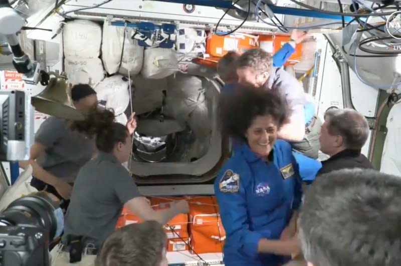 NASA astronauts Butch Wilmore and Suni Williams (pictured in blue) will be working a week more at the International Space Station, NASA officials said Tuesday. File NASA image/UPI