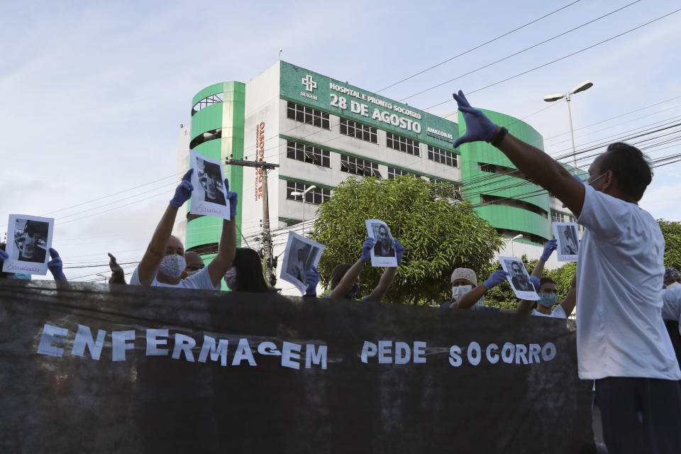 Health professionals hold up photos of people they said were their colleagues who died of COVID-19, behind a banner with the Portuguese phrase: "Nurses ask for help" as they protest outside "Pronto Socorro 28 de Agosto" Hospital, in Manaus, Brazil, Monday, April 27, 2020. Cases of the new coronavirus are overwhelming hospitals, morgues and cemeteries across Brazil as Latin America’s largest nation veers closer to becoming one of the world’s pandemic hot spots. (AP Photo/Edmar Barros)