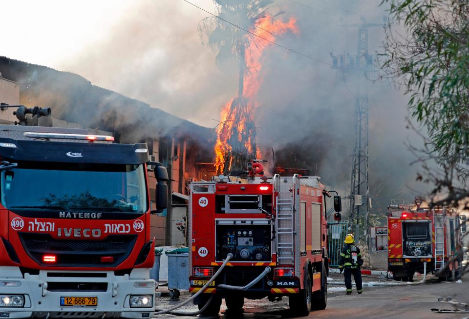 Israeli firefighter trucks douse a burning factory in the southern Israeli town of Sderot, after it was reportedly hit with rockets fired from the Gaza Strip on Tuesday. Israel's military killed a commander of Palestinian militant group Islamic Jihad in a strike on his home in Gaza early in the morning, prompting retaliatory barrages of rocket fire from the Gaza Strip towards Israel where residents ran to bomb shelters while air raid sirens rang out in various parts of the country.