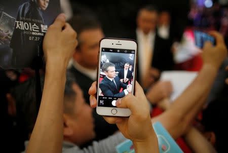 A fan takes photographs of actor Matt Damon on the red carpet event promoting his new film "Jason Bourne" in Seoul, South Korea July 8, 2016. REUTERS/Kim Hong-Ji