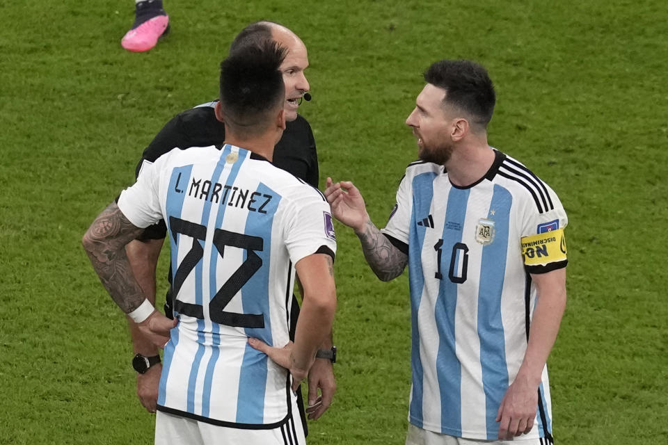 Argentina's Lionel Messi, right, and Argentina's Lautaro Martinez argue with referee Antonio Mateu during the World Cup quarterfinal soccer match between the Netherlands and Argentina, at the Lusail Stadium in Lusail, Qatar, Friday, Dec. 9, 2022. (AP Photo/Thanassis Stavrakis)