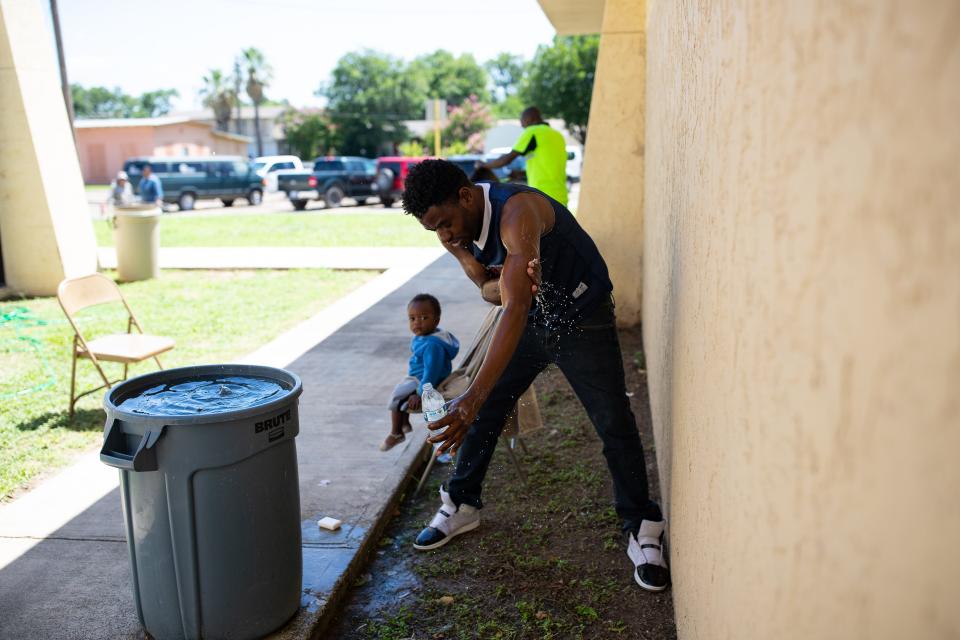 DEL RIO, Texas – Un migrante se baña usando el agua sucia que descarga una unidad de aire acondicionado rota en el Centro de la Coalición Humanitaria de la Frontera Val Verde el 25 de junio del 2019, mientras esperaba por un autobús que lo transportara al Centro de Recursos para Inmigrantes de San Antonio.