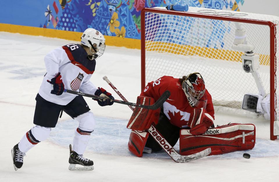 Canada's goalie Labonte makes a save on Team USA's Coyne during the first period of their women's ice hockey game at the 2014 Sochi Winter Olympics