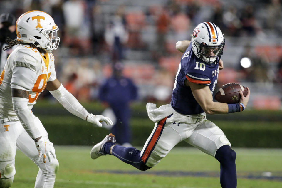 Auburn quarterback Bo Nix (10) scrambles away from Tennessee linebacker Kivon Bennett (95) during the second half of an NCAA college football game Saturday, Nov. 21, 2020, in Auburn, Ala. (AP Photo/Butch Dill)