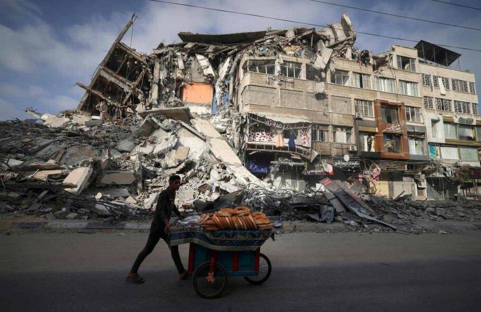 A Palestinian walks past the destroyed Al-Shuruq building in Gaza City on May 20, 2021 after it was bombed by an Israeli airstrike.