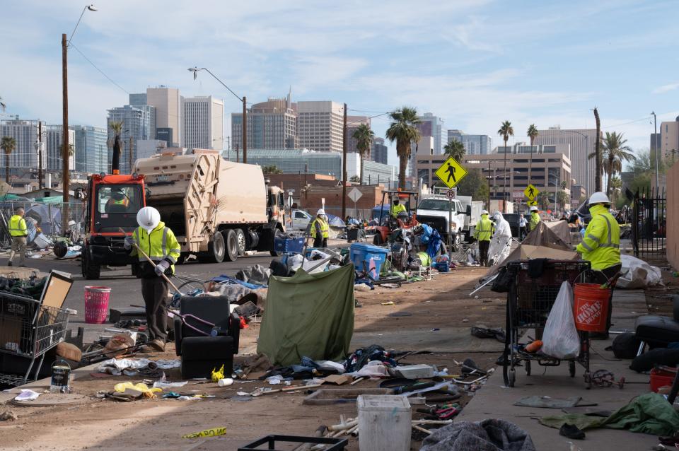 Workers remove debris from Madison Street (between 12th and 13th Avenues) on Dec. 16, 2022, during Phoenix's enhanced cleanup of the area.