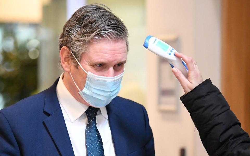 Sir Keir Starmer has his temperature checked as he arrives for a visit to Chelsea and Westminster Hospital, London -  Stefan Rousseau/PA