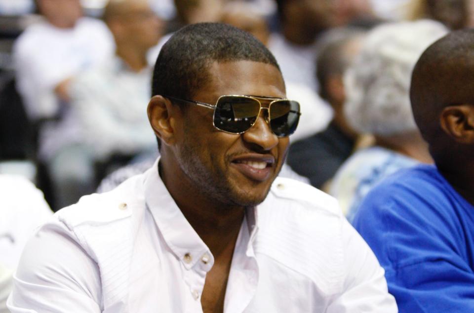 Recording artist Usher looks on in the first half of Game 3 of the Eastern Conference Finals NBA basketball playoff series between Orlando Magic and Cleveland Cavaliers in Orlando, Florida May 24, 2009. REUTERS/Scott Audette (UNITED STATES SPORT BASKETBALL ENTERTAINMENT) - GM1E55P0TUN01