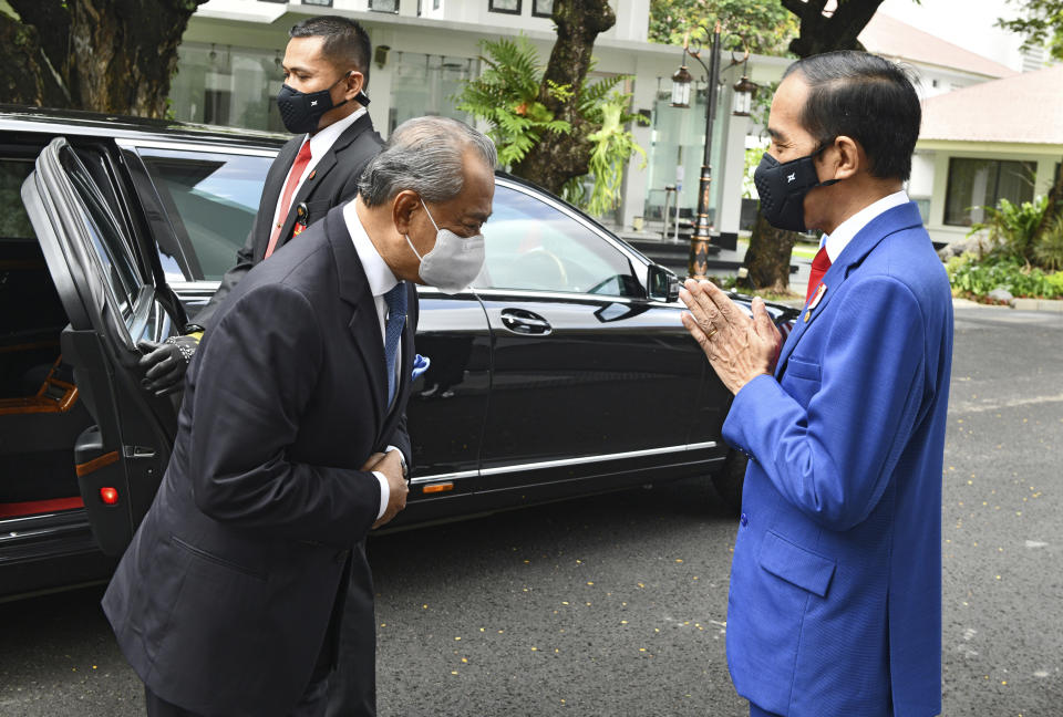 In this photo released by Indonesian Presidential Palace, President Joko Widodo, right, greets Malaysian Prime Minister Muhyiddin Yassin during their meeting at Merdeka Palace in Jakarta, Indonesia, Friday, Feb. 5, 2021. Yassin is currently on a two-day visit in the country. (Agus Suparto, Indonesian President Palace via AP)