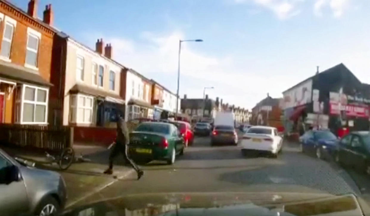 Disturbing dash-cam footage shows the moment a cyclist appears to stab a car passenger with a giant blade during a shocking broad daylight knife attack. (SWNS)