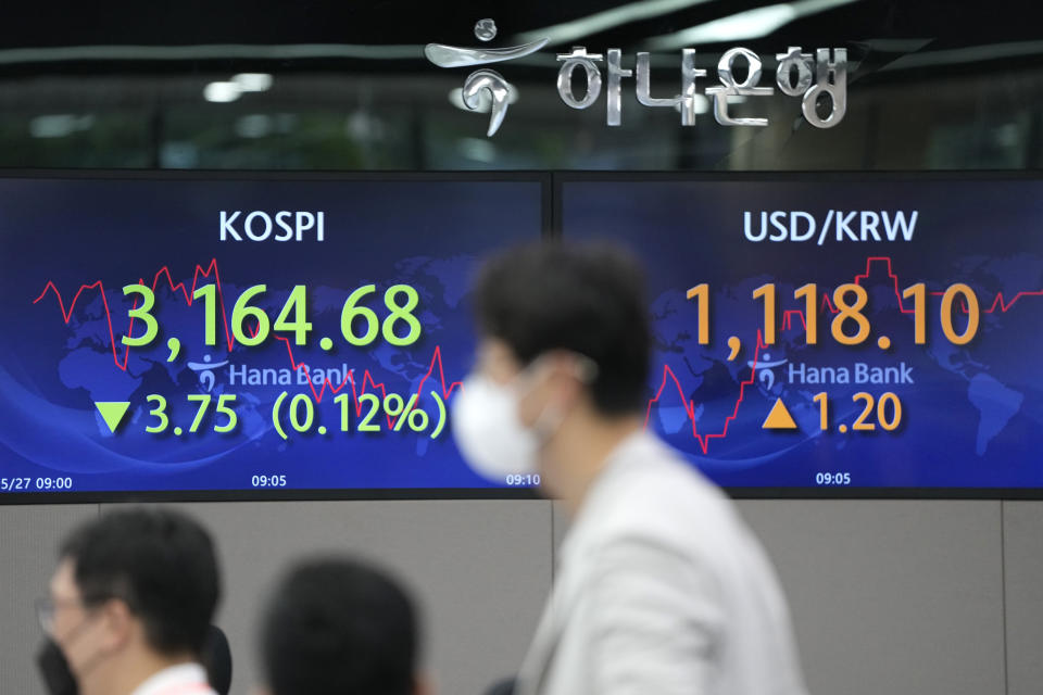 Currency traders watch computer monitors near the screens showing the Korea Composite Stock Price Index (KOSPI), left, and the foreign exchange rate between U.S. dollar and South Korean won at the foreign exchange dealing room in Seoul, South Korea, Thursday, May 27, 2021. Asian shares fell Thursday, as investors watched for signs of inflation and awaited U.S. economic data expected later in the day. (AP Photo/Lee Jin-man)