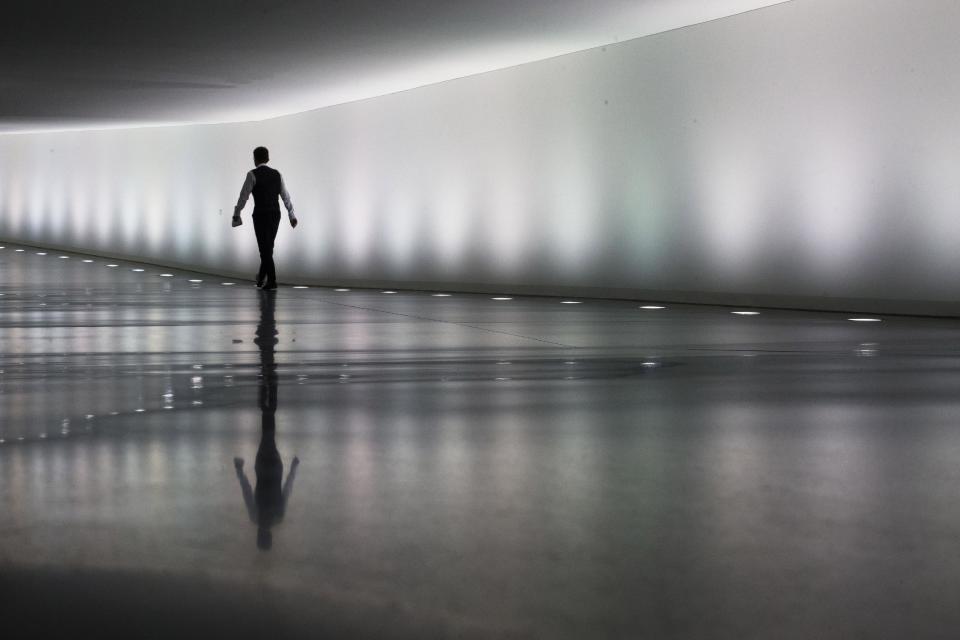 A staff member of the German parliament Bundestag walks through a tunnel between parliament buildings in Berlin, Monday, Sept. 10, 2012. During the first week after the summer break the German parliament will face the budget debate and a decision of Germany's Federal Constitutional Court about the European Stability Mechanism. (AP Photo/Markus Schreiber)