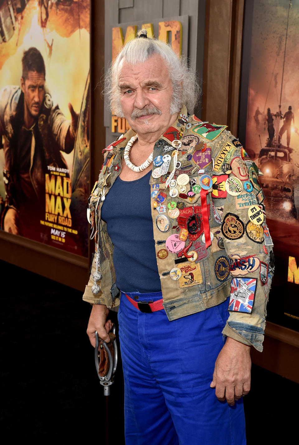 Actor Hugh Keays-Byrne wearing blue pants and a jacked covered in colourful patches at the premiere of Warner Bros. Pictures' "Mad Max: Fury Road" at TCL Chinese Theatre on May 7, 2015 in Hollywood, California.