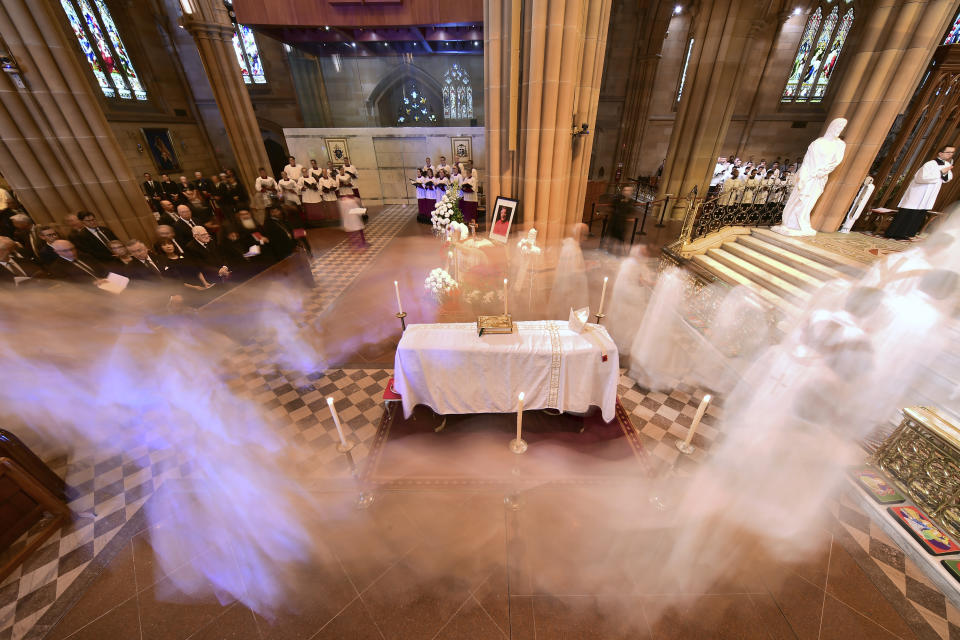 Clergy walk past the coffin of Cardinal George Pell during his funeral mass at St. Mary's Cathedral in Sydney, Thursday, Feb. 2, 2023. Pell, who died last month at age 81, spent more than a year in prison before his sex abuse convictions were overturned in 2020. (Giovanni Portelli/Pool via AP)