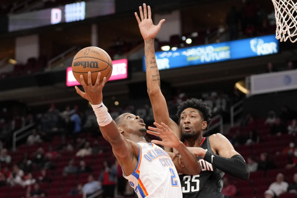 Oklahoma City Thunder guard Shai Gilgeous-Alexander (2) shoots as Houston Rockets center Christian Wood defends during the first half of an NBA basketball game, Monday, Nov. 29, 2021, in Houston. (AP Photo/Eric Christian Smith)