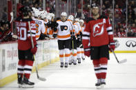 Philadelphia Flyers left wing James van Riemsdyk, center, skates by the bench after scoring a goal on the New Jersey Devils during the second period of an NHL hockey game, Saturday, Jan. 12, 2019, in Newark, N.J. (AP Photo/Julio Cortez)