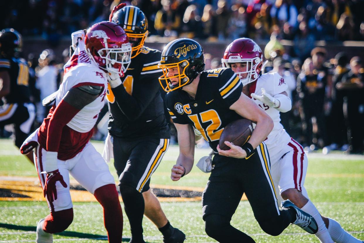 Missouri quarterback Brady Cook (12) scrambles during a game against Arkansas on Nov. 25, 2022, in Columbia, Mo.