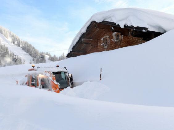 An excavator clears snows in the Austrian Alps (AP)