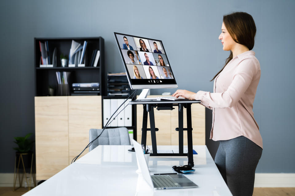 Adjustable Height Desk Stand In Office Using Computer The physiotherapist recommends people invest in a standing desk to reduce the amount of pressure your back withstands. (Getty)