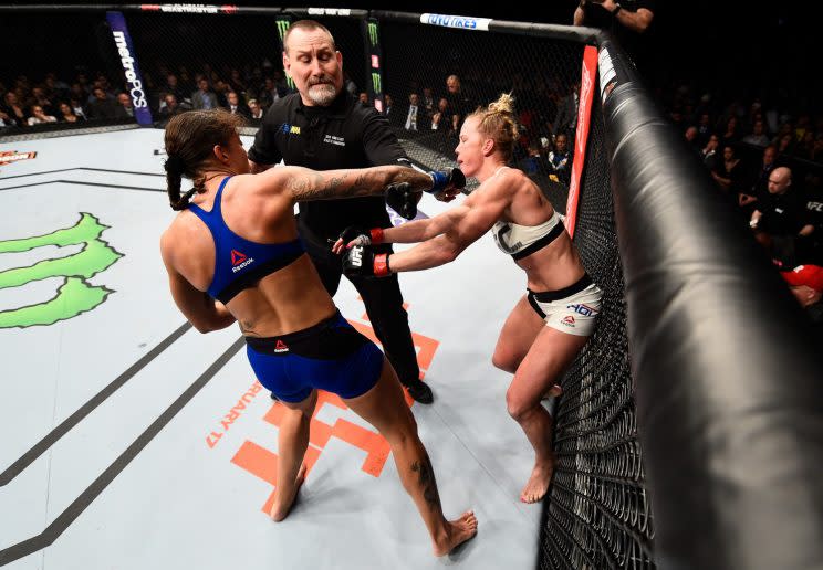 Germaine de Randamie (L) connects with a right hand on Holly Holm thrown after the bell to end the second round of their featherweight title fight Saturday in the main event of UFC 208. Referee Todd Anderson did not penalize de Randamie. (Getty Images)