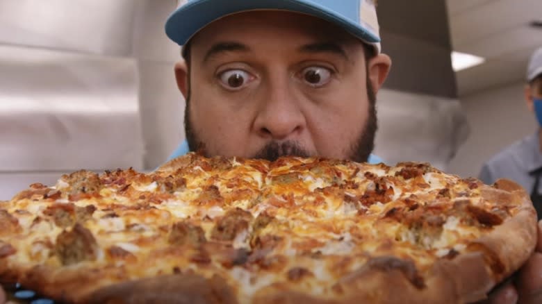 Adam Richman holding a Domino's breakfast pizza