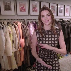 Kendall stands in front of several racks of clothing