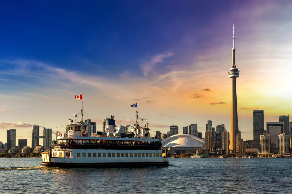 Panoramic view of Toronto skyline and CN Tower and ferry at sunset, Ontario, Canada
