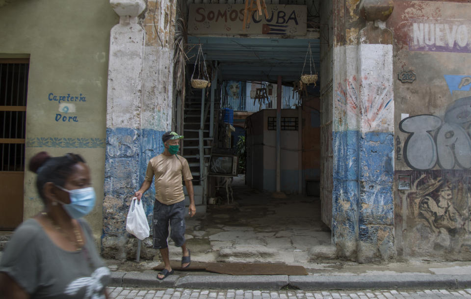 People venture outdoors wearing masks as a precaution amid the worldwide spread of the new coronavirus in Havana, Cuba, Thursday, June 18, 2020. All of Cuba has moved to phase one with the exception of Havana, the capital of 2 million people where the small number of new daily cases has been concentrated. (AP Photo/Ismael Francisco)