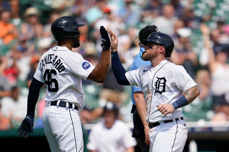 Detroit Tigers' Jeimer Candelario (46) and Tucker Barnhart celebrate scoring against the San Francisco Giants in the fifth inning of a baseball game in Detroit, Wednesday, Aug. 24, 2022. (AP Photo/Paul Sancya)