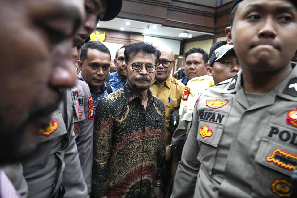 Former Indonesian Agriculture Minister Syahrul Yasin Limpo, center, is escorted by police officers after his sentencing at the Corruption Court in Jakarta, Indonesia Thursday, July 11, 2024. Indonesia's anti-graft court sentenced Limpo to 10 years in prison Thursday after finding him guilty of corruption-related extortion, abuse of power and bribery involving ministry contracts with private vendors. (AP Photo/Tatan Syuflana)