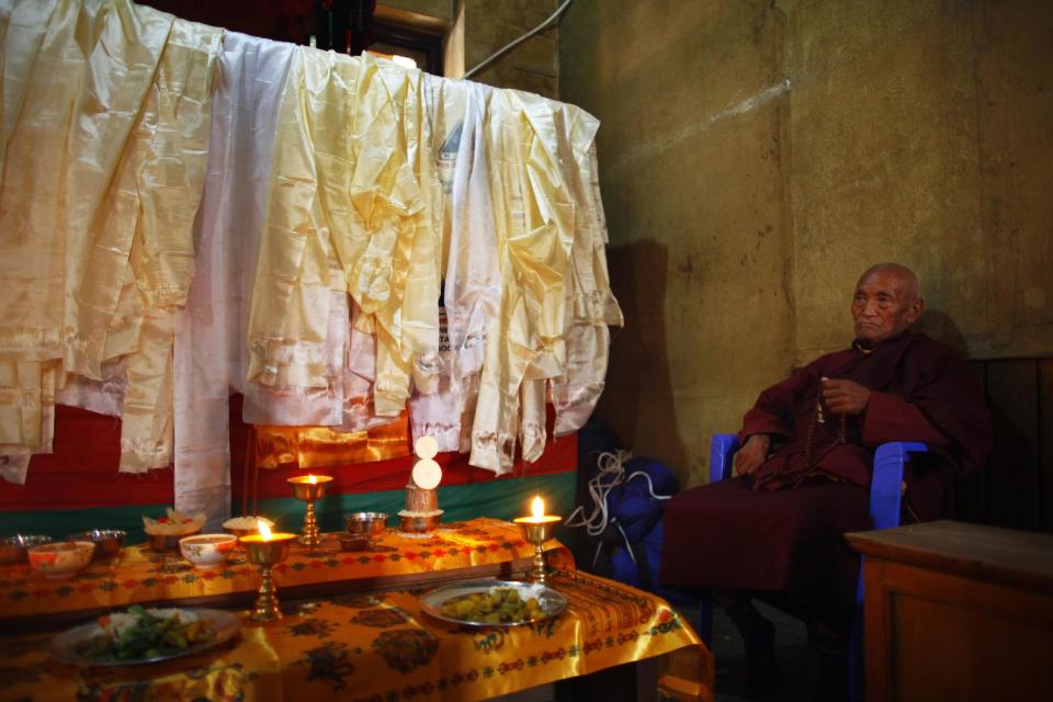 A Buddhist monk performs rituals next to a casket containing the dead body of Nepalese mountaineer Ang Kaji Sherpa, killed in an avalanche on Mount Everest, offer prayers at the Sherpa Monastery in Katmandu, Nepal, Sunday, April 20, 2014. Rescuers were searching through piles of snow and ice on the slopes of Mount Everest on Saturday for four Sherpa guides who were buried by an avalanche that killed 12 other Nepalese guides in the deadliest disaster on the world's highest peak. The Sherpa people are one of the main ethnic groups in Nepal's alpine region, and many make their living as climbing guides on Everest and other Himalayan peaks. (AP Photo/Niranjan Shrestha)