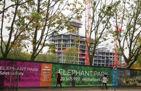 People pass a sign for the Elephant Park building development in Elephant and Castle south London, Britain October 5, 2015. REUTERS/Neil Hall