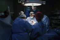 Doctors perform surgery on a patient at Al-Aqsa Martyrs Hospital, in Deir al-Balah, central Gaza, Sunday, March 17, 2024. An international team of doctors has been working the past two weeks at the facility amid shortages of supplies. (AP Photo/Abdel Kareem Hana)