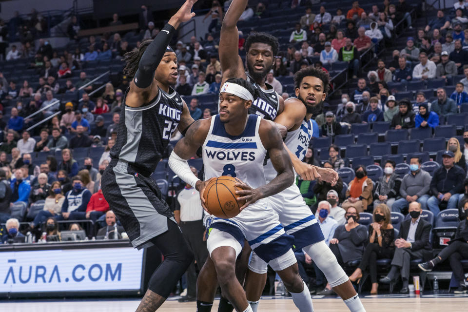 Minnesota Timberwolves forward Jarred Vanderbilt (8) tries to get around Sacramento Kings forward Richaun Holmes, left, and forward Chimezie Metu as Timberwolves center Karl-Anthony Towns, right, sets a screen during the first half of an NBA basketball game Wednesday, Nov. 17, 2021, in Minneapolis. (AP Photo/Craig Lassig)