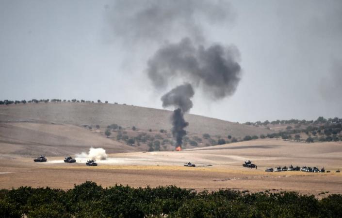 Turkish army tanks and pro-Ankara Syrian opposition fighter trucks pictured two kilometres west of the Syrian town of Jarabulus, in an image taken from the Turkish border city of Karkamis on August 24, 2016 (AFP Photo/Bulent Kilic)